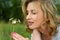 Young girl sniffing wild wild flower in the field