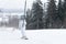 Young girl snowboarder rises on a lift up the hill