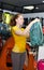 Young girl in a specialty store for the tourism picks backpack.