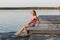 The young girl splashes by his feet in the lake