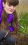 The young girl squatted next to the seedlings in her garden