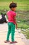 Young girl standing on the bank of Yamuna river in oversized flip-flops, Agra, Uttar Pradesh, India