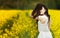 Young girl standing in a field. Close up outdoor fashion sunny portray of young beautiful girl with big amazing smile and long flu