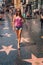 Young girl standing at the Hollywood walk of fame