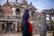 Young girl standing infront of a Sacred Buddhist Monastery. Sculptures of Gods and Goddesses carved on the stone of Ancient