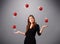 Young girl standing and juggling with red balls