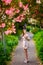 Young girl standing near tree with flowers