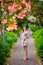 Young girl standing near tree with flowers