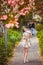 Young girl standing near tree with flowers