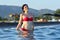 Young girl standing in sea water on background of beach