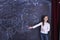 Young girl stands at the blackboard