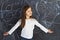 Young girl stands at the blackboard