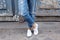 Young girl stands in the sneakers crosslegged