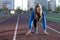 Young girl stands at the start on a treadmill, woman runner exercise on the street