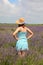 young girl with straw hat in the field of lavender flowers in the European plain s