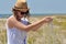 Young girl in a straw hat, sand in hands