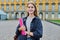 Young girl student posing outdoors, background of educational building