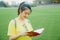 Young girl student reads a book on grass field in the afternoon in campus