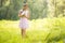 Young girl in summer light dress collecting wild flowers