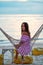 A young girl in a sundress resting in a hammock on the beach .the view from the back