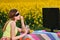 Young girl in sunglasses watches tv in the field dines on chips
