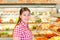 Young girl in a supermarket vegetable department