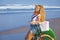 Young girl with surfboard and bicycle