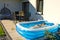 Young girl swimming in inflatable swimming pool on home backyard terrace. Staycation sta home concept