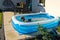 Young girl swimming in inflatable swimming pool on home backyard terrace. Staycation sta home concept