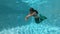 Young girl swims underwater like a mermaid
