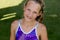 Young girl in a swimsuit on a shelf by the pool