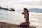 Young girl in a swimsuit standing on the beach at sunset