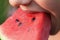Young girl take a watermelon bite - extreme closeup