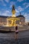 Young girl taking a picture of the famous Fountain of the Three Graces in Place de la Bourse at sunset