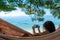 Young girl taking a picture with a smartphone lying in a hammock on a beach