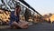 Young girl talking on phone sitting on a pedestrian bridge.