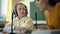 Young girl and teacher using headphones and microphone in the classroom