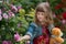 Young girl with teddy bear in the garden of wild rose