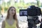 A young girl tells the news to the camera. Blogger. Journalist. News reporting