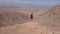 Young girl together with her dog puppy looks at the panorama on the summit of a volcanic mountain