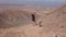 Young girl together with her dog puppy looks at the panorama on the summit of a volcanic mountain