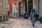 A young girl tourist in a fashionable brown hat is walking along a small street with cobblestones