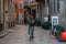 Young girl tourist in a fashionable brown hat is walking down the street with a cobblestone