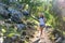 Young girl tourist in a hat on a walk on a mountain forest road, in the ruins of the ancient city Termessos in the bright rays of