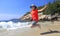 Young girl tourist jumping on Sand Beach in Acadia National Park, Maine