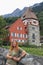 Young girl tourist and the oldest house in the Principality of Liechtenstein - Red House, medieval European architecture and a vin