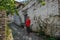 Young girl tourist in a pink blouse is standing on a cobbled road in the ancient Albanian city of Berat