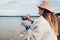 Young girl tourist pours hot tea out of thermos by autumn lake enjoying landscape. Travelling.