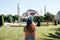 A young girl traveler in a hat from the back in Sultanahmet Square next to the famous Aya Sofia mosque in Istanbul