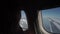 Young girl travels by plane, sits by window and enjoys view through porthole.